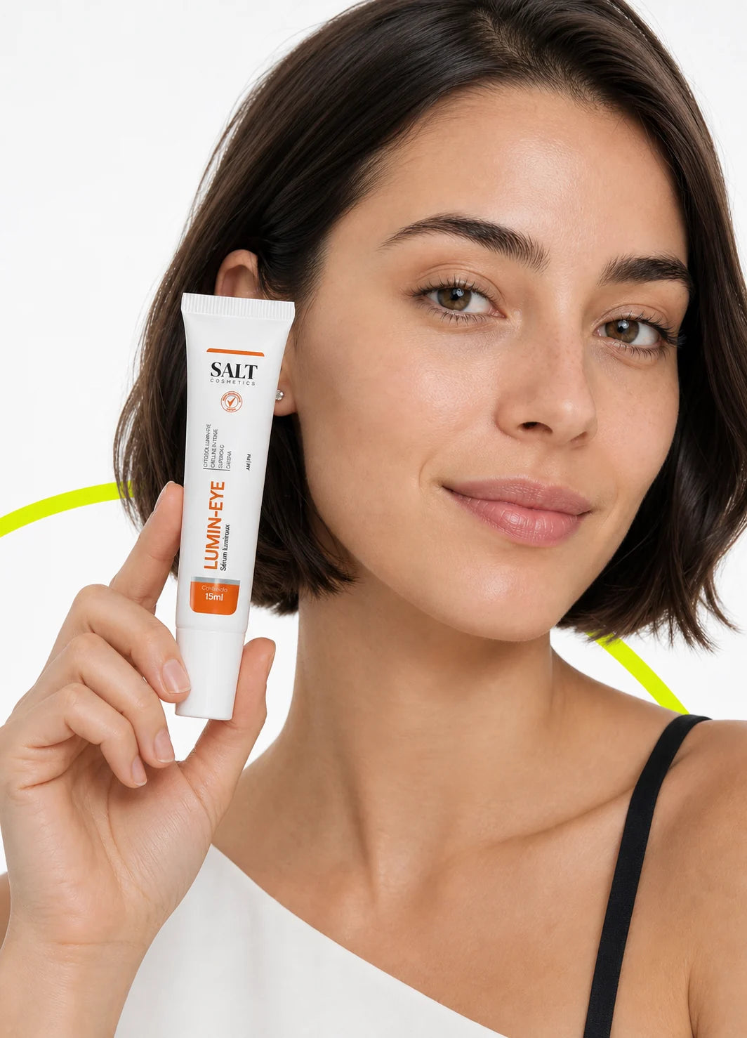 Mulher segurando o sérum Lumin-Eye da Salt Cosmetics junto ao rosto